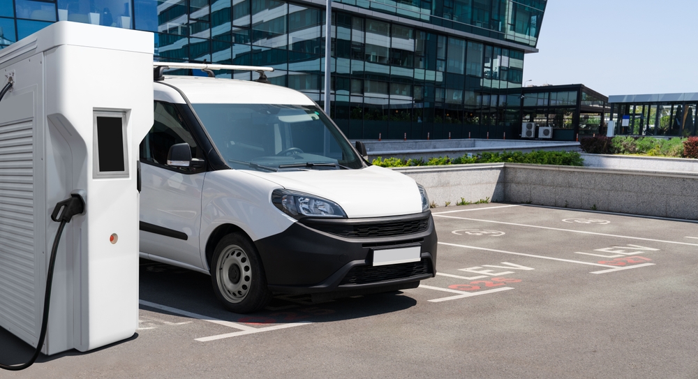Luxury electric vehicle being securely loaded onto an enclosed transport trailer for long-distance shipping