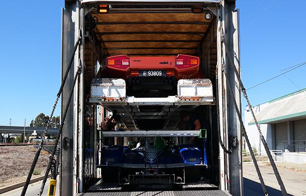 Enclosed transport truck carrying a luxury vehicle